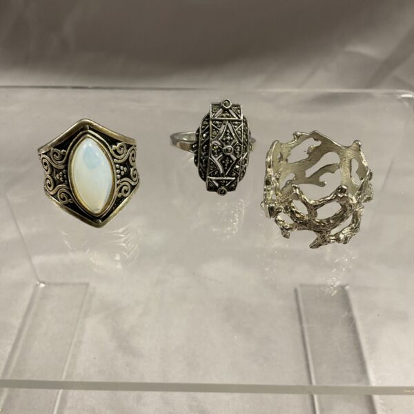Close-up of a silver floral ring, part of a lot.