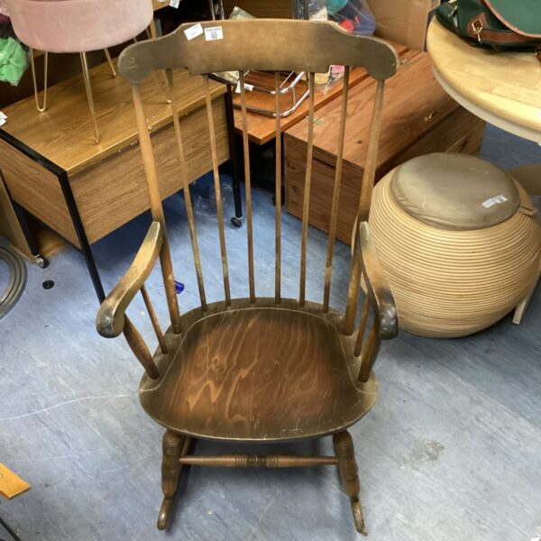 Vintage wooden rocking chair with spindle back, antique farmhouse style.