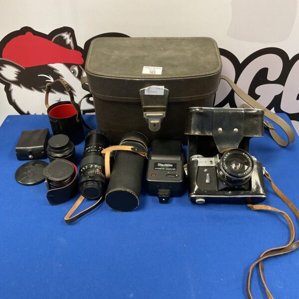 Vintage Zenit-e camera with lenses and flash in a lot.