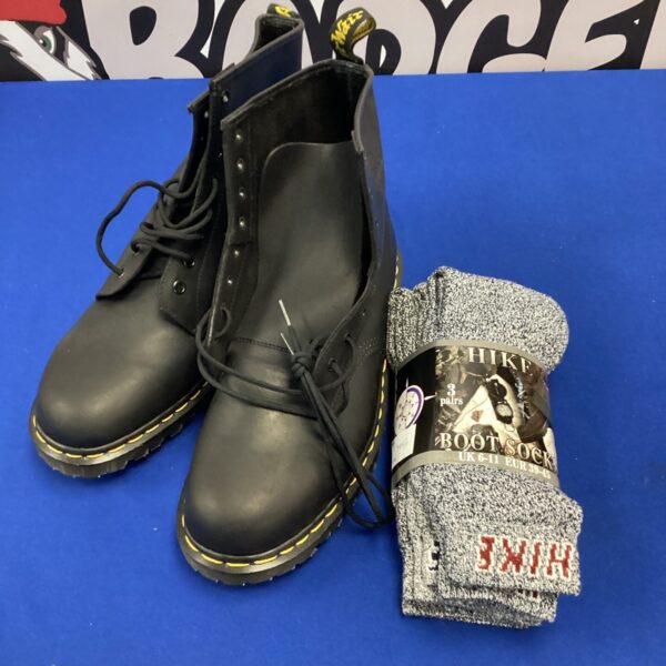 Black Dr Martens boots and hiking socks for sale.