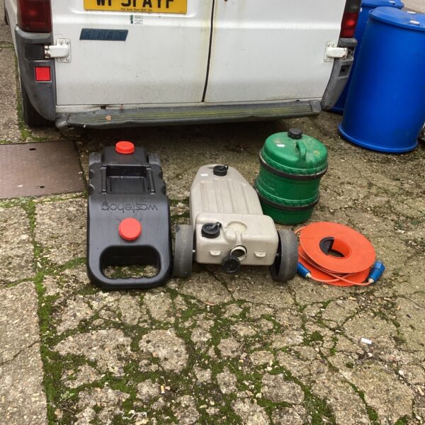 Lot of used camping waste barrels and containers.