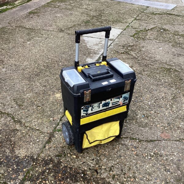 Blue and yellow plastic tool box on wheels for workshop storage.