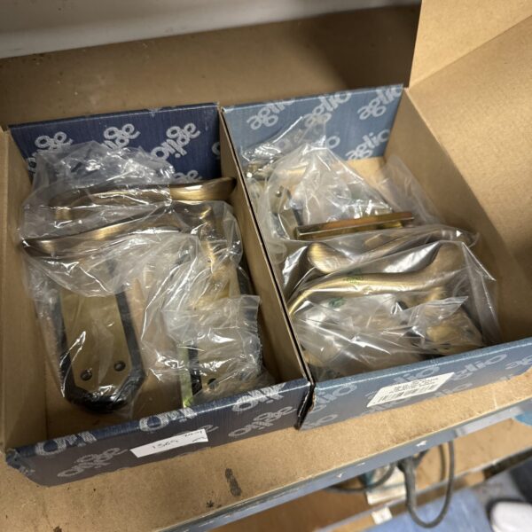Two pairs of new black and bronze Aglio door handles in packaging.