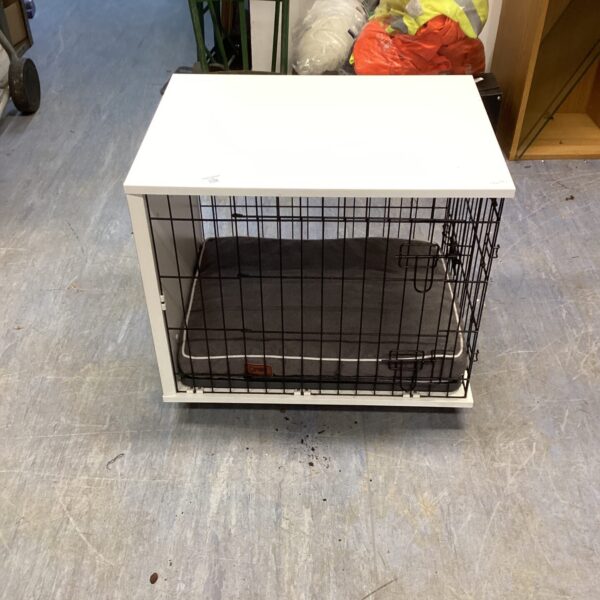 White small dog cage with a padded bed inside.