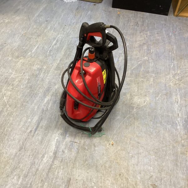 Red Champion power washer with black handle for garden cleaning.