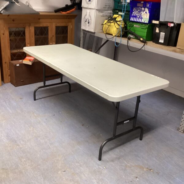 White 6ft folding table for events and camping, showing signs of use.