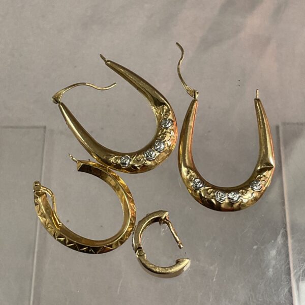 Close-up of 9ct gold scrap earrings with curved design.