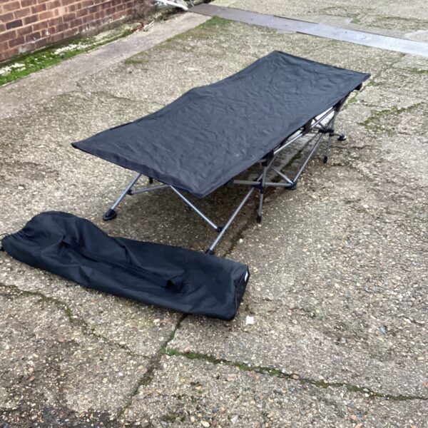 Outdoor folding camp bed showing signs of wear.