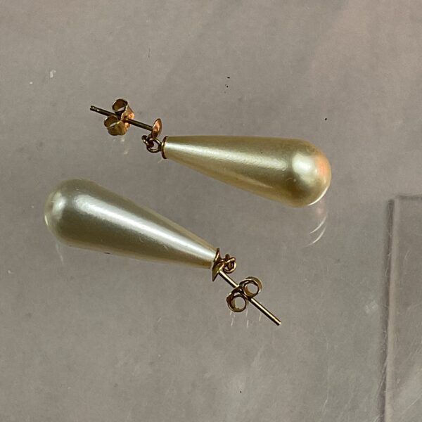 Close-up of 9ct gold drop earrings with a teardrop shape.