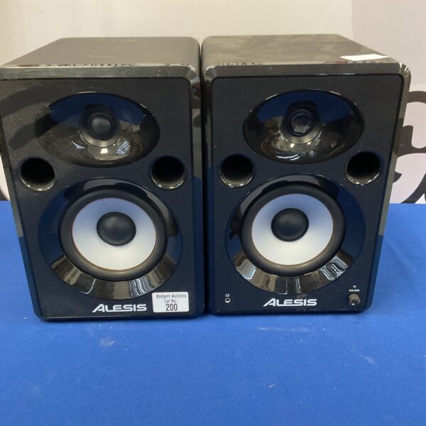 Pair of black Alesis Elevate 5 studio monitors on a blue background.