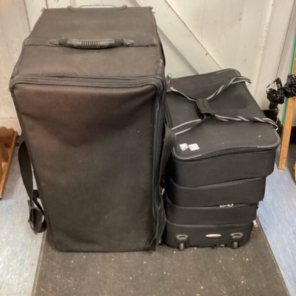 Stack of three black shoe sample cases for footwear.