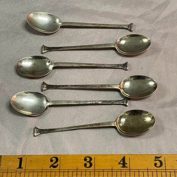 Lot of six hallmarked sterling silver teaspoons on a ruler.