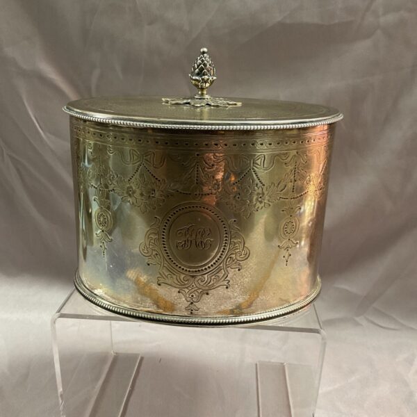 Intricate Victorian sterling silver tea caddy on a stand.