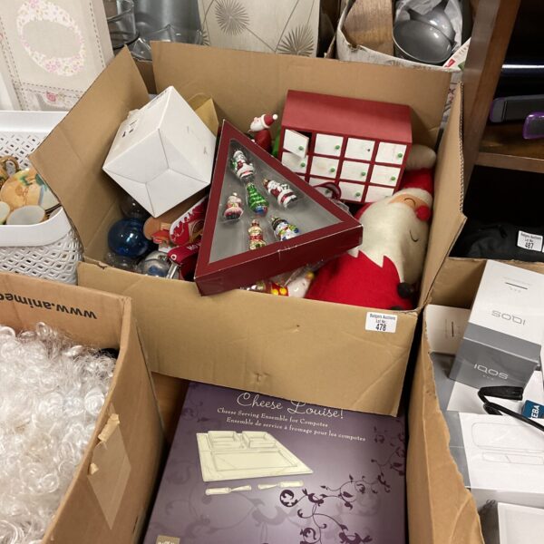 Assorted vintage and modern Christmas decorations in a cardboard box.