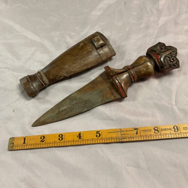 Antique Asian dagger with carved wooden handle and curved blade.
