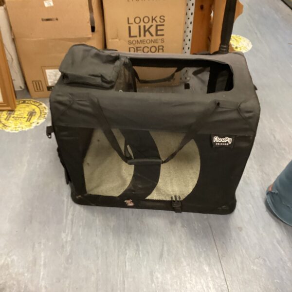 Front view of a used floofy pet carrier with a handle.