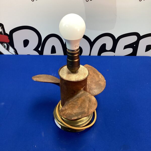 Unique steampunk table lamp with ship's propeller shade.