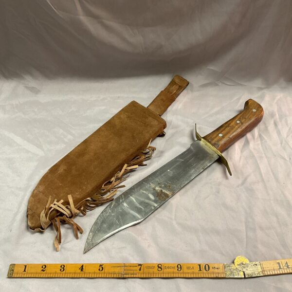 Vintage Bowie knife with leather sheath, a collectible hunting knife.