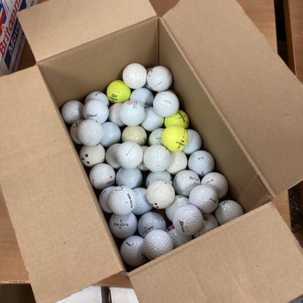 Mixed lot of used golf balls for practice and play.