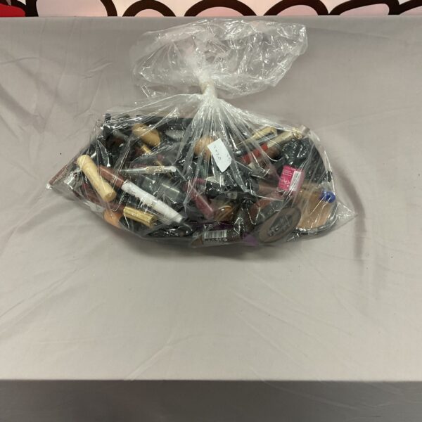Mixed cosmetics lot with assorted beauty products in a plastic bag.