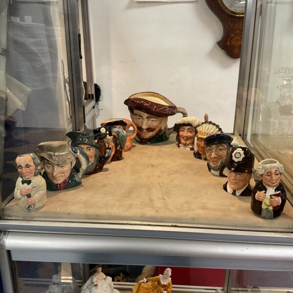 Vintage Royal Doulton character jugs in a collection.