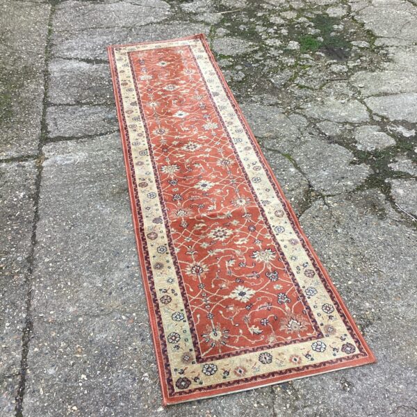 Vibrant orange Keshan runner rug with floral patterns.