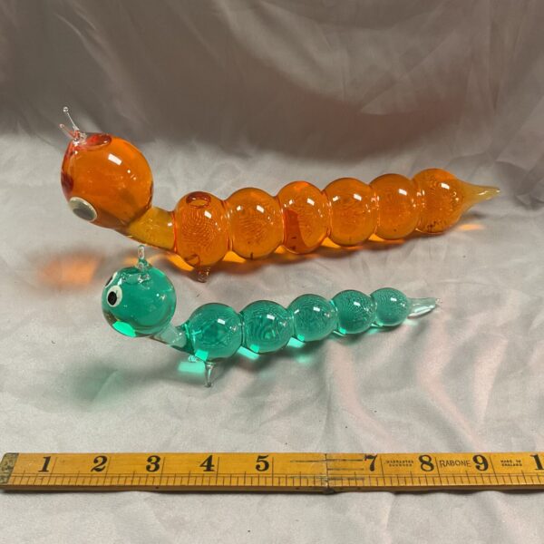 Vintage glass caterpillar figurine with green and orange segments.
