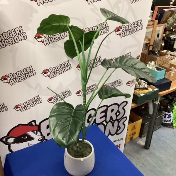 Realistic artificial potted plant with large green leaves.