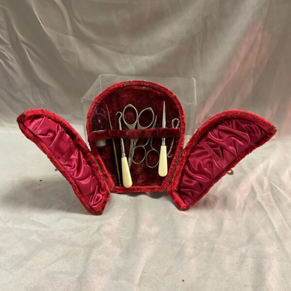 Antique Victorian sewing set in a red horseshoe case with ivory tools.