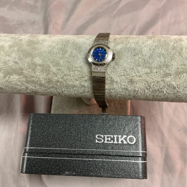 Ladies Seiko watch with blue dial and gold bracelet.