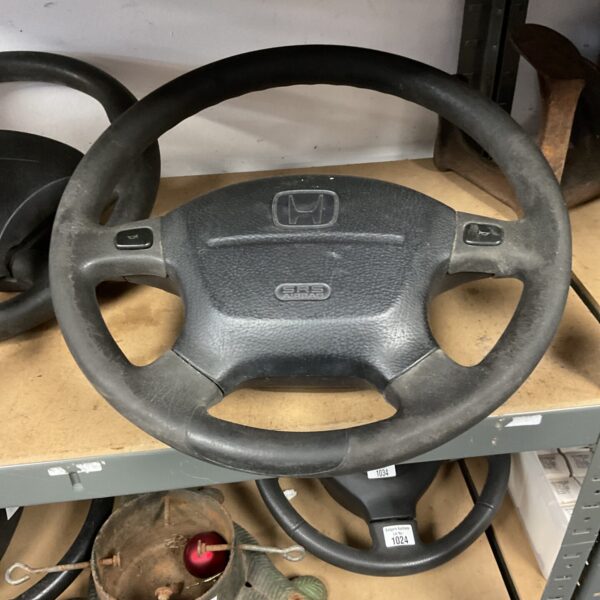 Grey Honda steering wheel with integrated controls, automotive part.