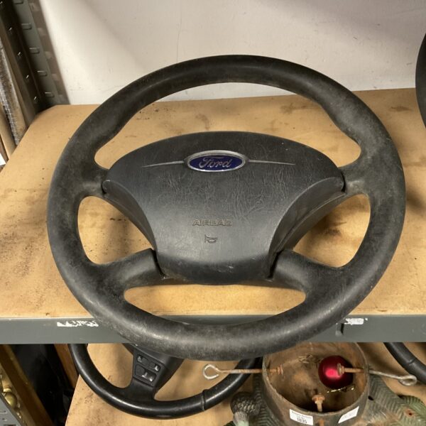 Grey Ford steering wheel with airbag cover, used condition.