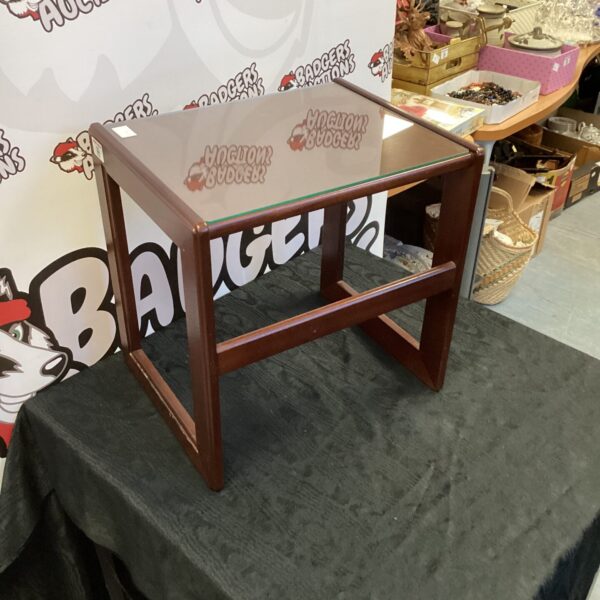 Small mahogany table with glass top for home decor.