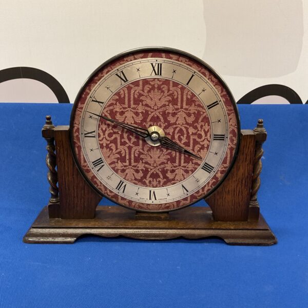 Vintage English mantle clock with a fabric face.
