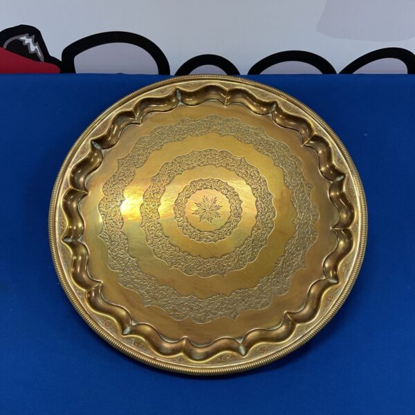Intricate floral etched Indian brass charger tray for display.