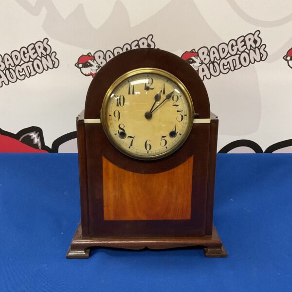 Antique Junghans mantle clock with wooden case and decorative face.