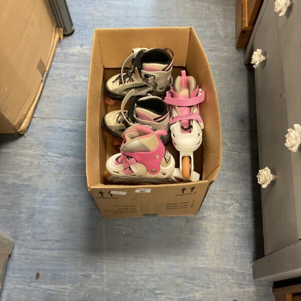 Pair of vintage childrens roller skates in a cardboard box.