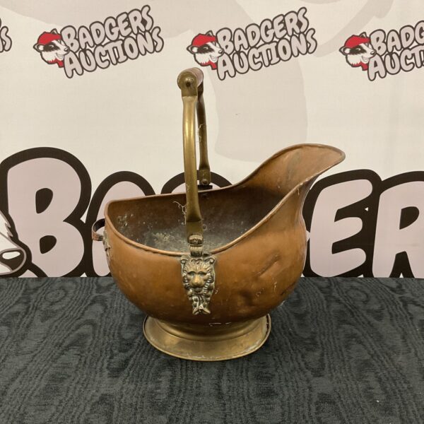 Antique copper coal scuttle with lion head details.