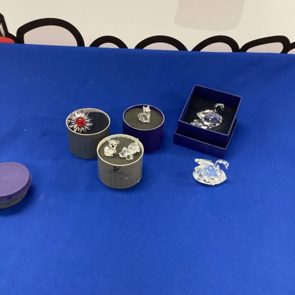 Five Swarovski crystal ornaments displayed in their presentation boxes.