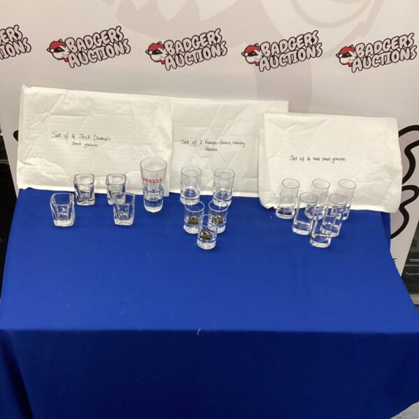 Collection of crystal shot glasses and whiskey tumblers on display.
