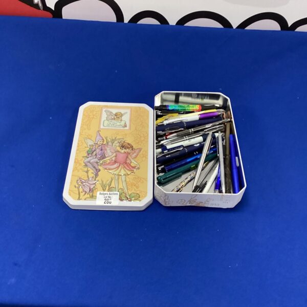 Vintage tin filled with a colourful collection of ballpoint pens.