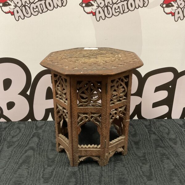 Intricately carved wooden Indian table with floral patterns.