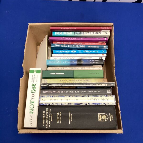 Stack of personal development books including Eckhart Tolle and Brené Brown.