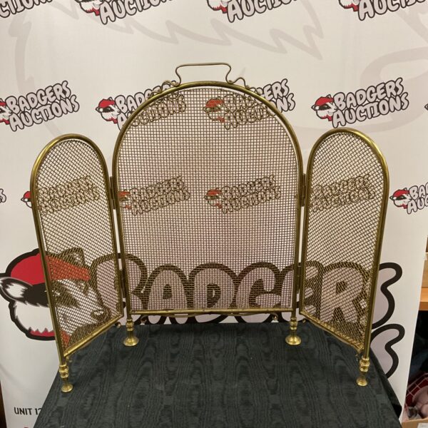 Vintage brass tri-fold fire screen for fireplace safety.