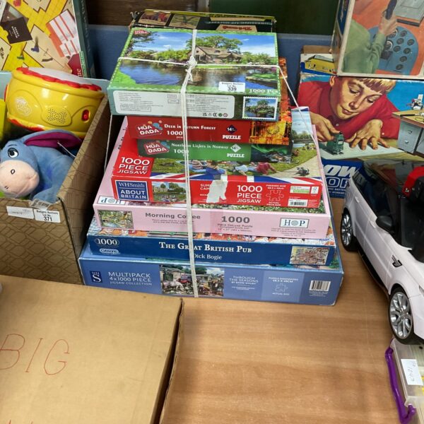 Mixed lot of jigsaw puzzles with colourful box art.