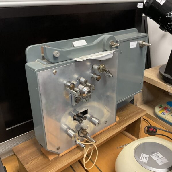 Side view of a vintage film winder with metal spools.