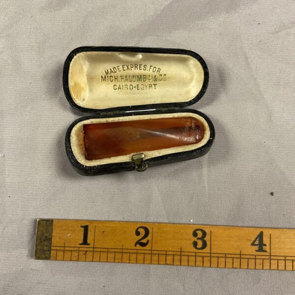 Vintage amber cigar holder in fitted case, collectible smoking accessory.