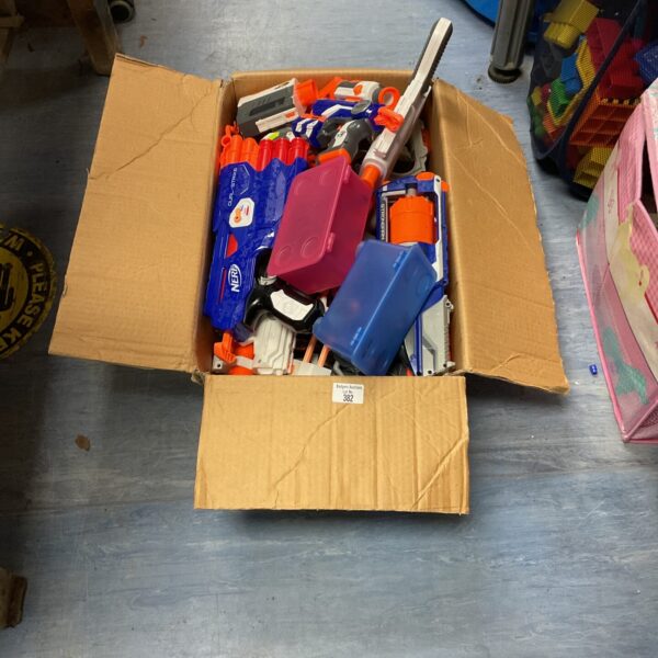 A box filled with various Nerf guns and foam darts.