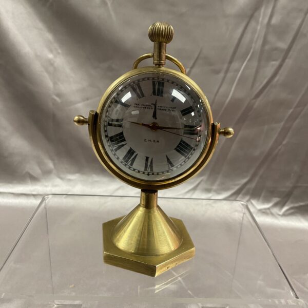 Vintage brass globe clock with clear face and stepped base.