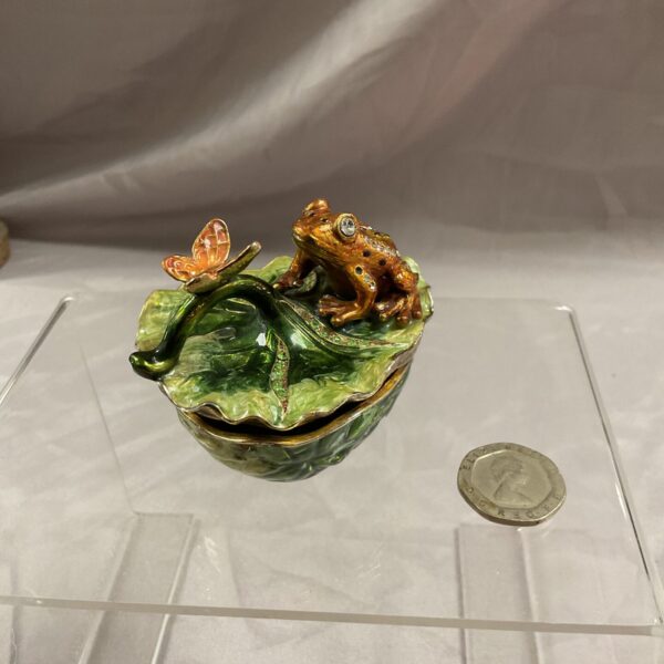 Vintage enamel frog trinket box on a green lily pad.